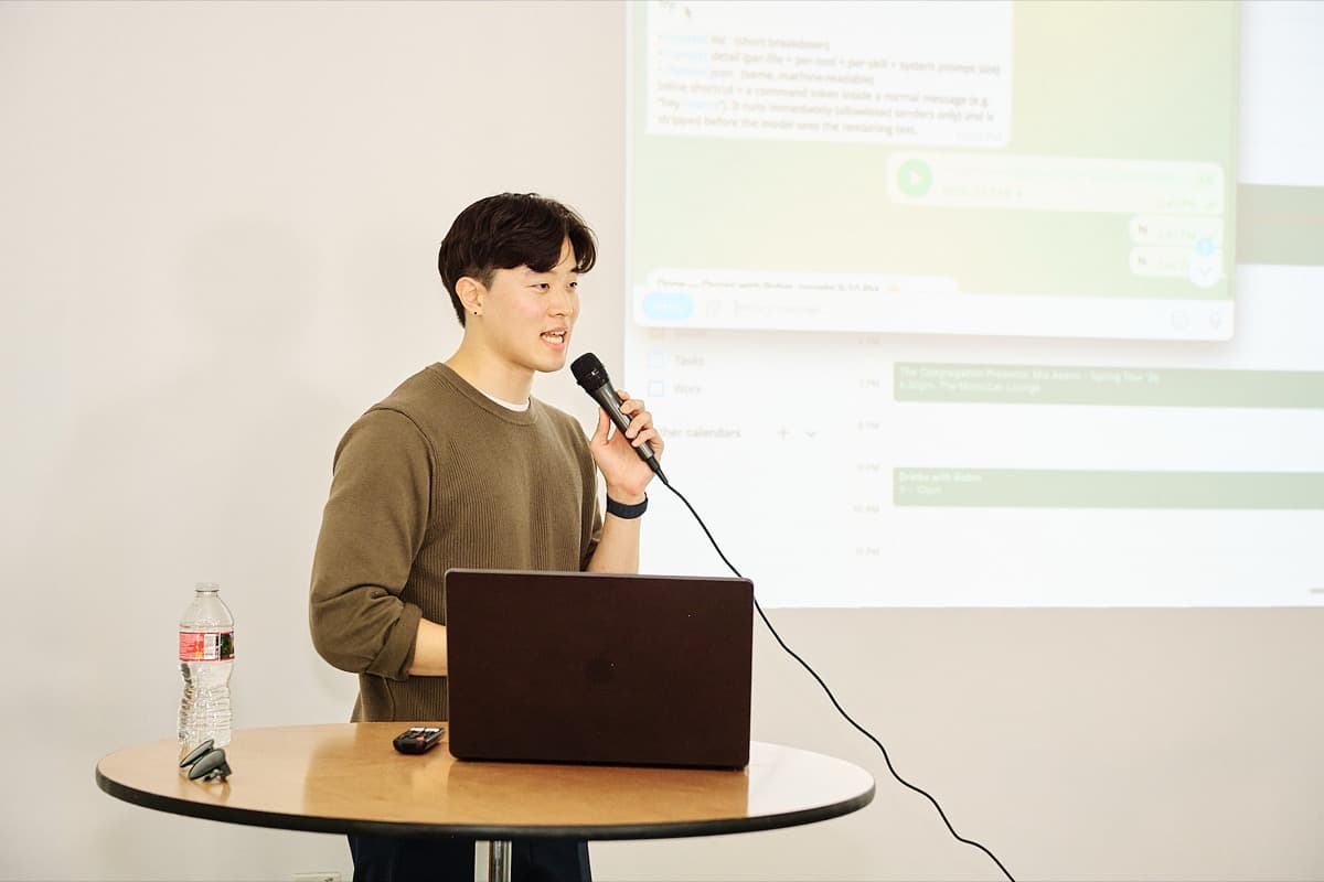 Speaker presenting with slides projected behind