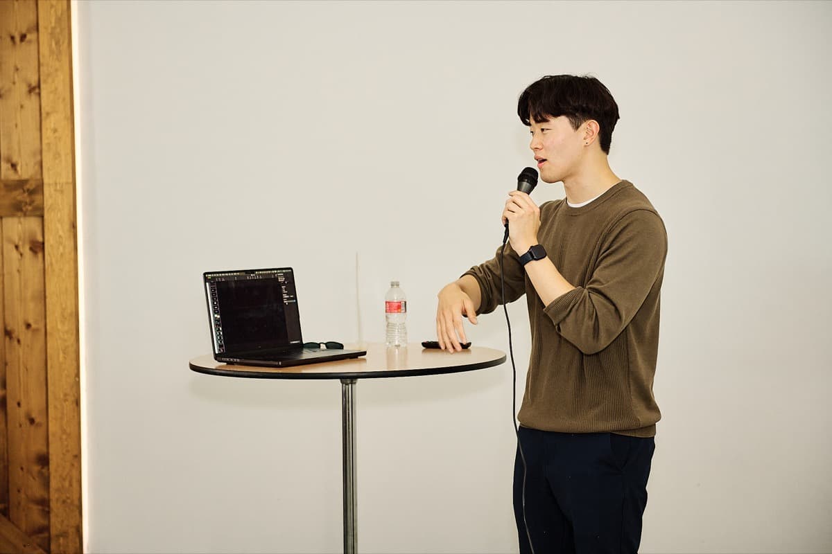 Presenter speaking at a table with laptop
